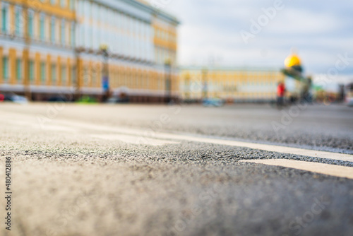 Rainy day in the city. The empty road. Historical center of the city. Focus on the asphalt. Close up view from the level of the dividing line.