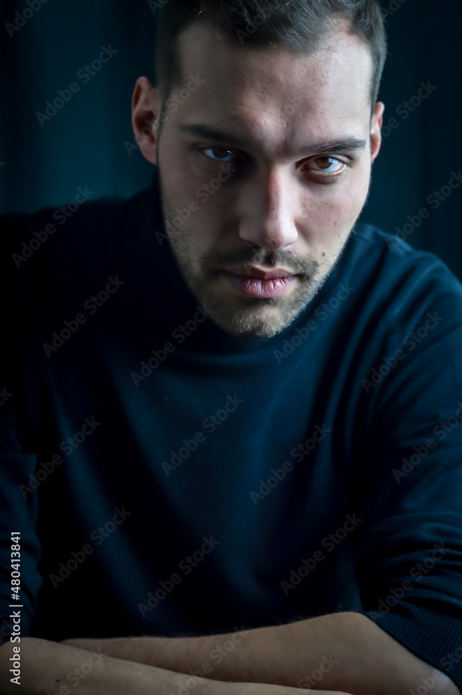 portrait of a young man in a black turtleneck with an intense and captivating look