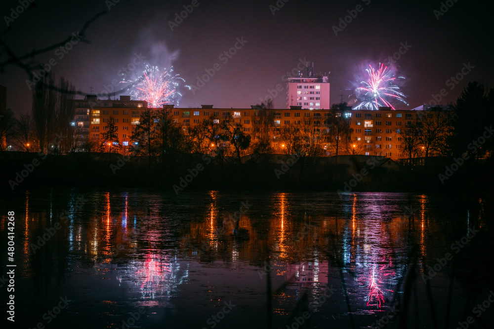 new years eve celebration with fireworks over city with reflections