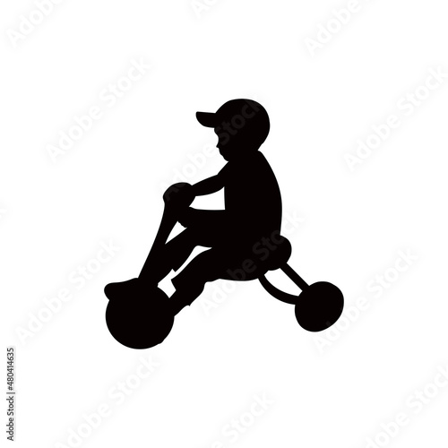 A boy rides a tricycle.