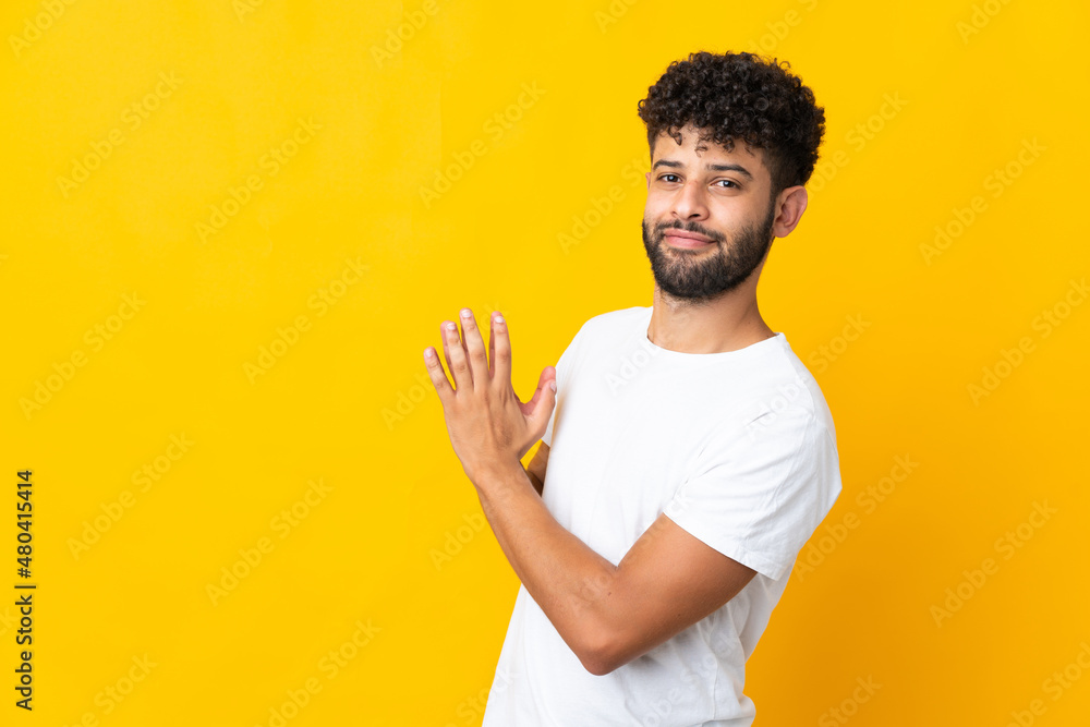 Young Moroccan man isolated on yellow background scheming something Young Moroccan man isolated on yellow background scheming something