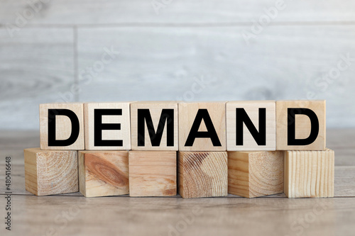 The word demand on stacked wooden cubes. Demand increase or rise in economy or business concept.