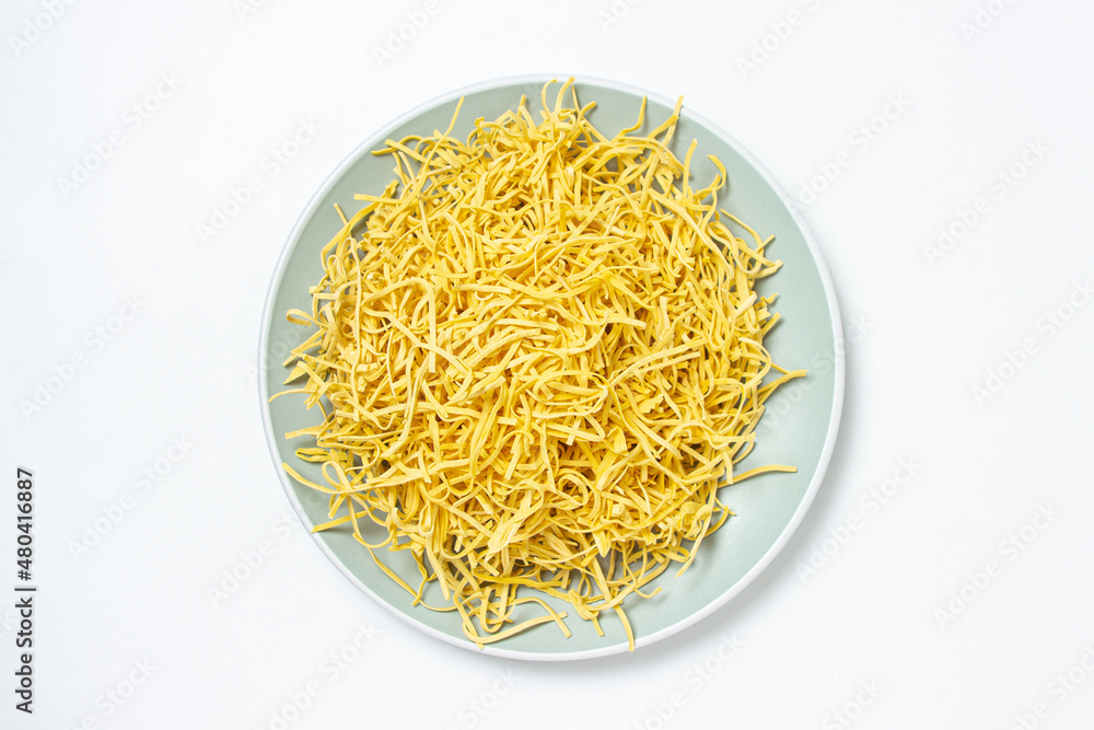 Egg noodles on a white background. Dry homemade noodles on a plate. Traditional pasta Egg noodles on a white background. Dry homemade noodles on a plate. Traditional pasta
