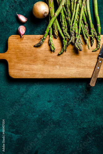 Asparagus, onion and garlic over cutting board. Food ingredients concept. Copy space, studio shot.