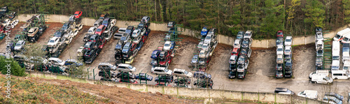 An automobile scrapyard full of cars with thermal engines. The electric car replaces the combustion engine car.