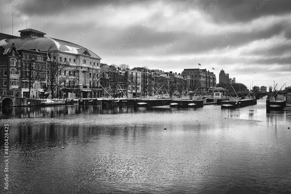 Naklejka premium View over the Amstel river in the historic city center of Amsterdam in classic Black and White