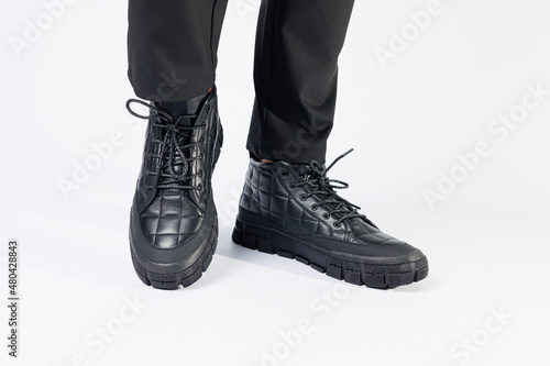 Men's black boots made of genuine leather, men's footwear on a white background. Winter men's shoes 2022