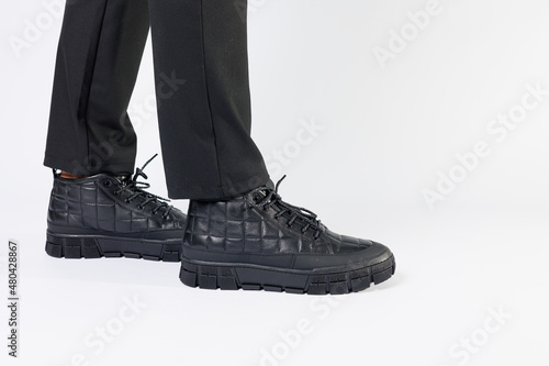 Men's black boots made of genuine leather, men's footwear on a white background. Winter men's shoes 2022