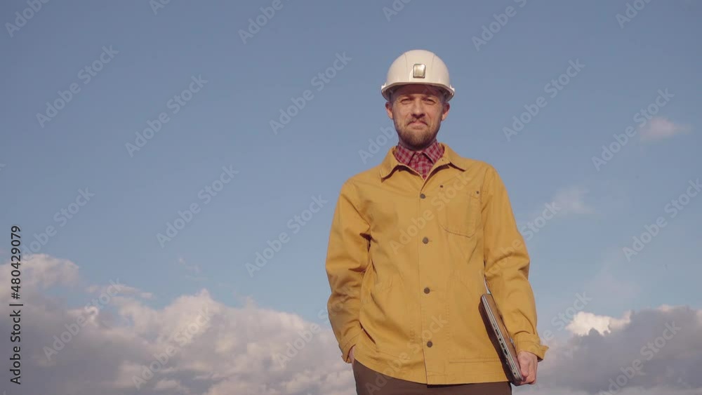 Thumbs up gesture, smiling and looking at camera. Cute caucasian chief technician, supervisor or construction architect in white helmet and orange jacket with laptop. High resolution 4k video footage Thumbs up gesture, smiling and looking at camera. Cute caucasian chief technician, supervisor or construction architect in white helmet and orange jacket with laptop. High resolution 4k video footage