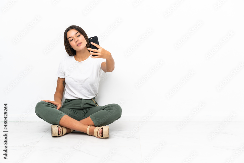 Teenager girl sitting on the floor making a selfie Teenager girl sitting on the floor making a selfie