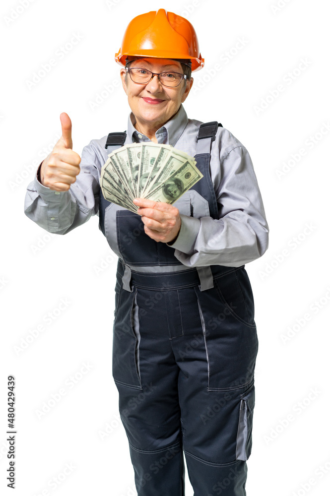 elderly woman, granny worker in special clothes holds a wad of money and shows the class. Woman, grandmother smiles, engineer contented, happy. isolated elderly woman, granny worker in special clothes holds a wad of money and shows the class. Woman, grandmother smiles, engineer contented, happy. isolated
