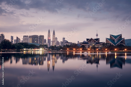 Urban skyline of Kuala Lumpur at dawn. Reflection of skyscrapers in the water surface.