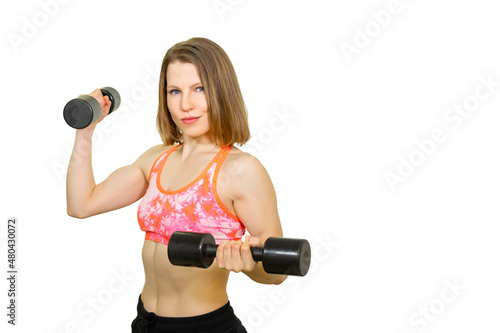 athletic, inflated girl posing with dumbbell on camera. isolated. Serious young woman athlete is looking at us. close-up