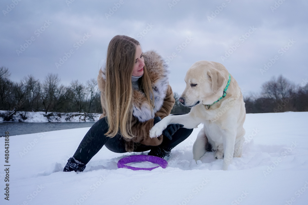 Girl with a white dog in the snow in winter