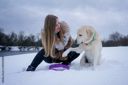 Girl with a white dog in the snow in winter © Pavel