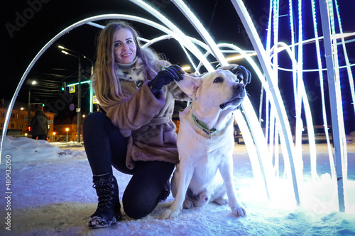 Girl with a white dog at the evening illuminations © Pavel