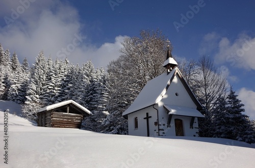 Die Schwandereckkapelle auf dem Weg zum Bildstöckle im Allgäu. Am Himmel zeigen sich vor kälte Schneekristalle.