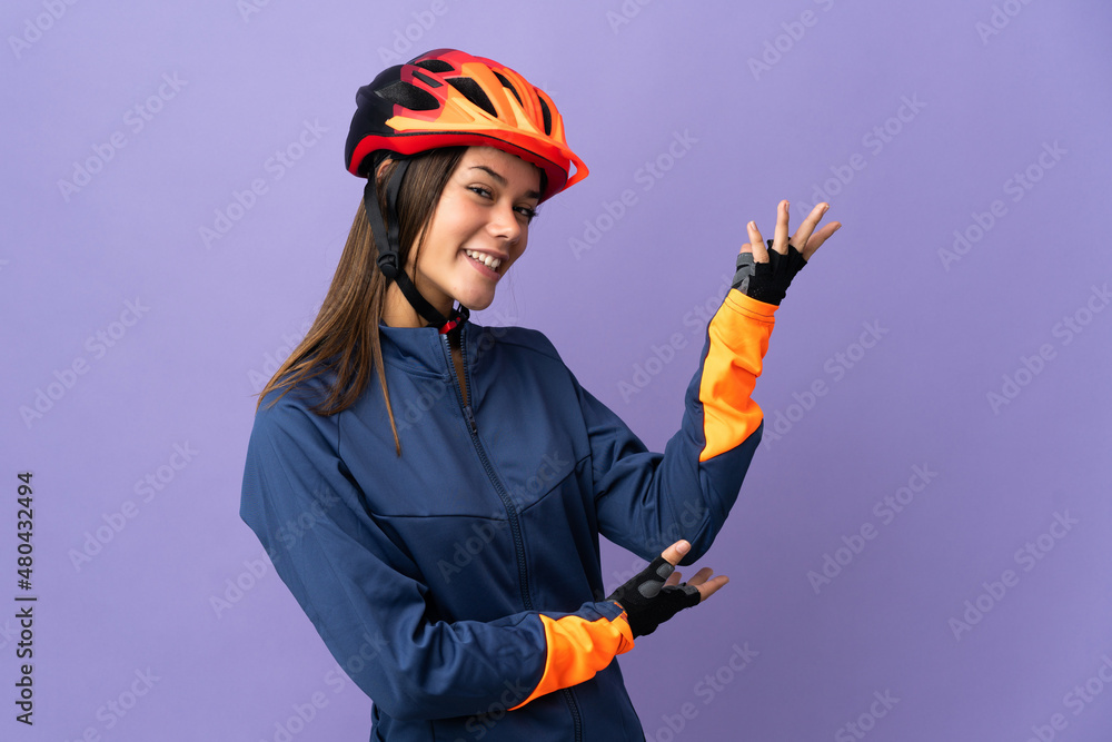 Teenager cyclist girl extending hands to the side for inviting to come