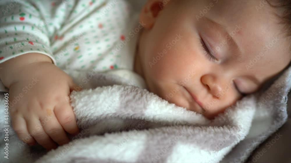 Newborn baby sleeps peacefully with sweet dreams covered with a blanket in the nursery. cute newborn boy is sleeping sweetly Newborn baby sleeps peacefully with sweet dreams covered with a blanket in the nursery. cute newborn boy is sleeping sweetly