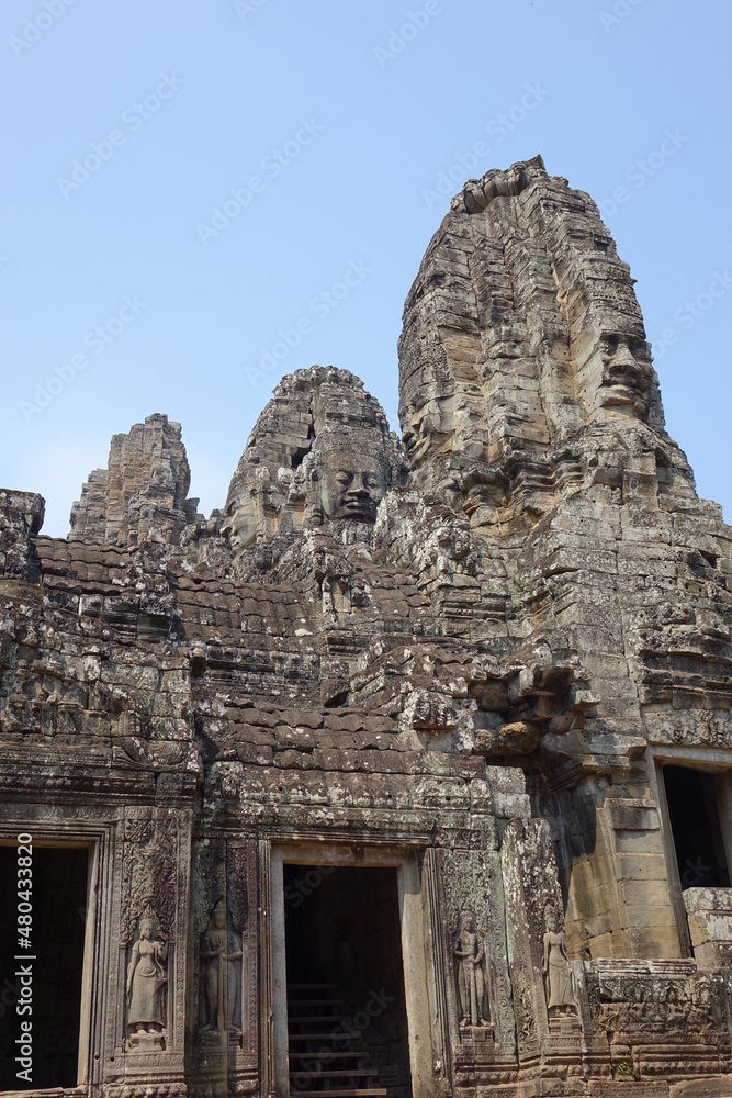 Adventure of exploring mystic Bayon temple in the impressive Khmer ruin city Angkor Thom (vertical image), Siem Reap, Cambodia