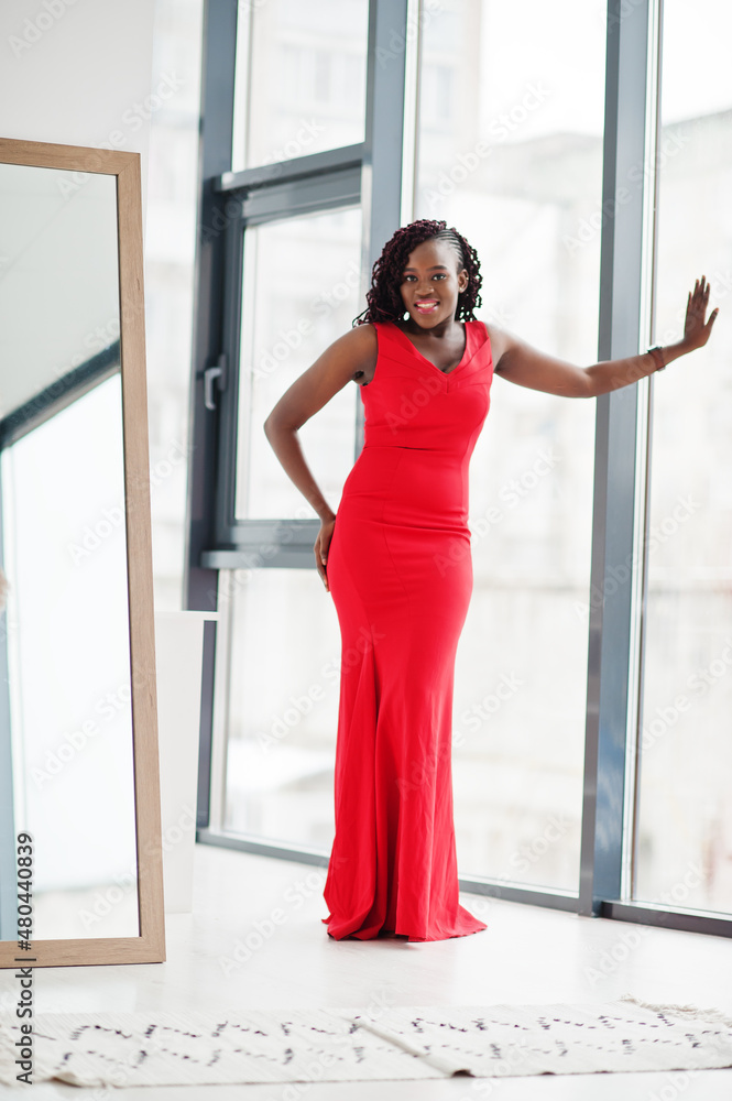 Magnificent young african woman in luxurious red dress in a luxury apartment. Beauty, fashion. Magnificent young african woman in luxurious red dress in a luxury apartment. Beauty, fashion.