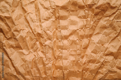 Brown crumpled brown paper background. Packing paper. Waste paper. Minimalistic paper surface for posters and banners