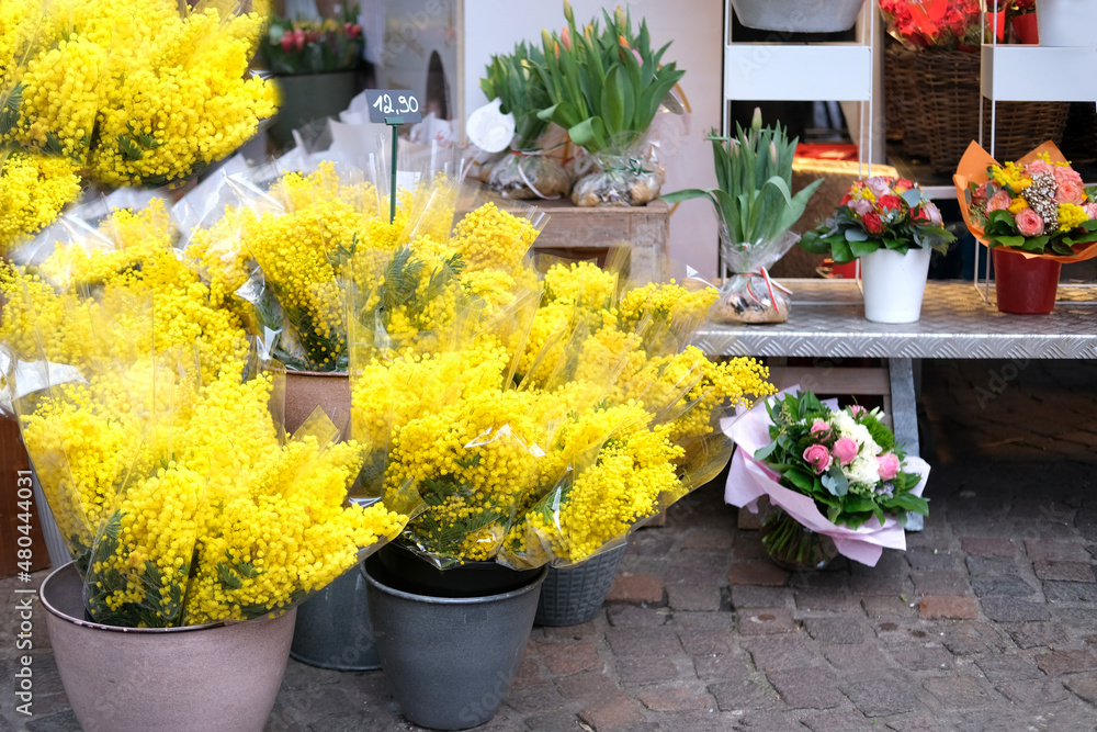 yellow mimosa branches in buckets, spring bouquets, romantic flower baskets in a street flower shop, romantic shopping concept, valentine's day, birthday present, foreground focus
