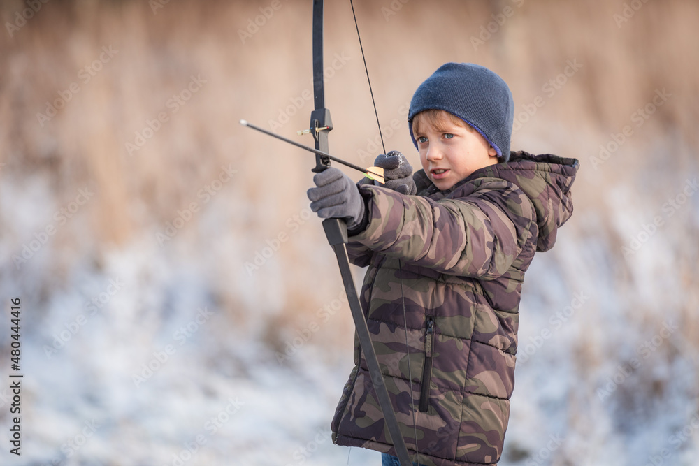 Portrait of a young boy shooting a bow. Portrait of a young boy shooting a bow.