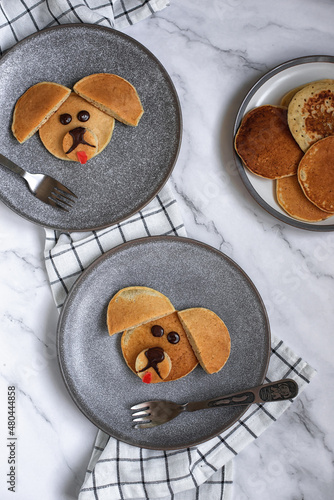 Creative breakfast for children. Funny pancake food art. Banana pancakes in the form of dogs.