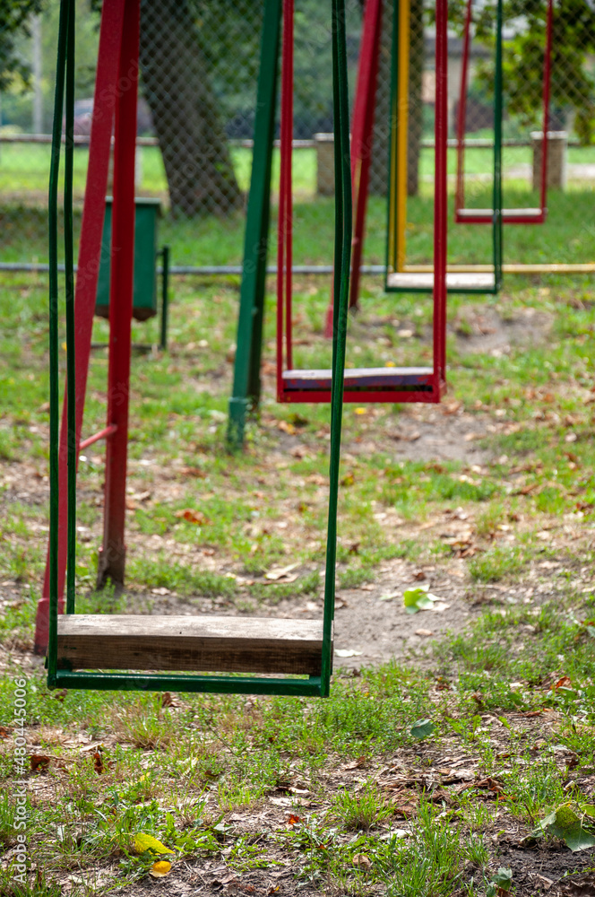 Childrens playground on the yard in summer. Rest with little child. swing in the park