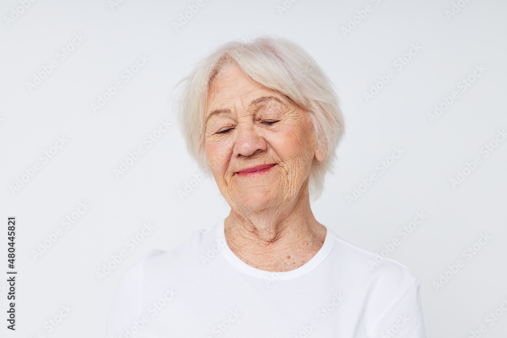 close-up of a cheerful elderly woman in a white t-shirt close-up of a cheerful elderly woman in a white t-shirt