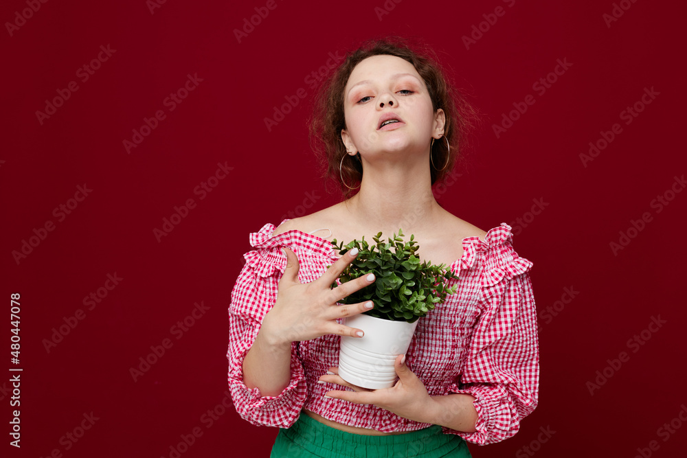 Young woman in green shorts flowerpot posing isolated background unaltered Young woman in green shorts flowerpot posing isolated background unaltered