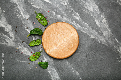 spinach leaves with peppers on black background with cutting board top view