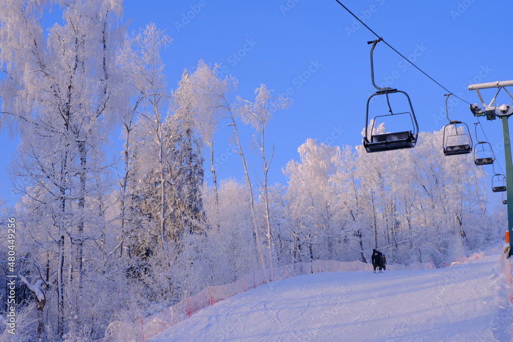 Obraz premium Snow-covered trees in hoarfrost at a ski resort, lift, funicular, ski lift