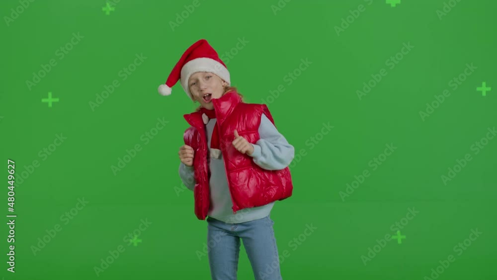 girl in hat of Santa Claus is counting on green screen . Lovely young Caucasian girl dancing . Happy kid singing a song girl in hat of Santa Claus is counting on green screen . Lovely young Caucasian girl dancing . Happy kid singing a song