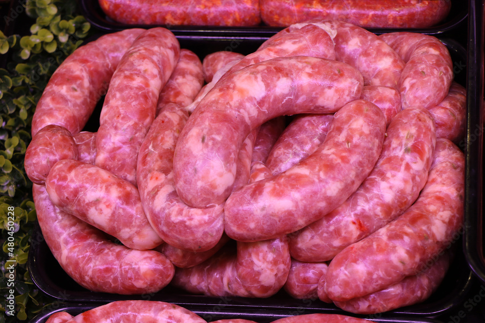 Fototapeta premium Raw Italian sausage ready to be cooked. Meat for sale in the butcher's shop