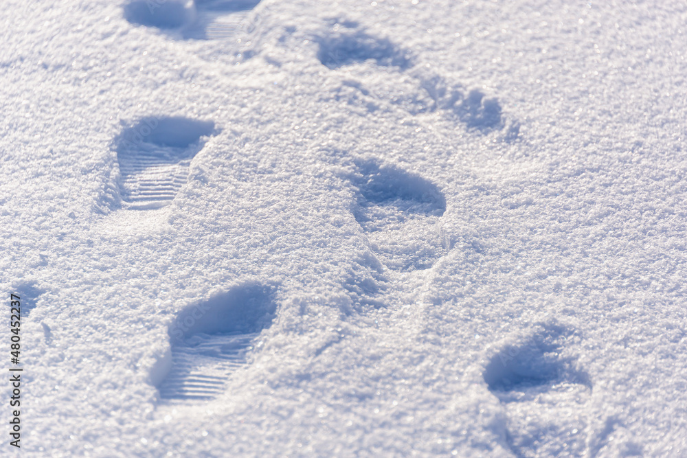 There are human footprints on the white snow. There are human footprints on the white snow.