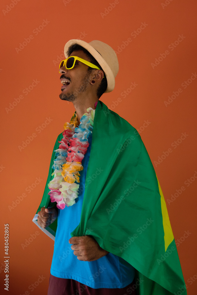 Black man in costume for carnival with brazil flag isolated on orange background. African man in various poses and expressions.