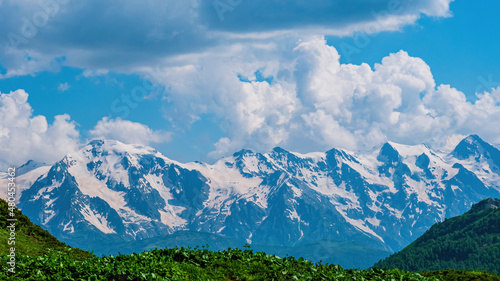 Idyllic landscape with blue sky, green grassland and snowcapped mountain top. Svanetia region, Georgia © maribom