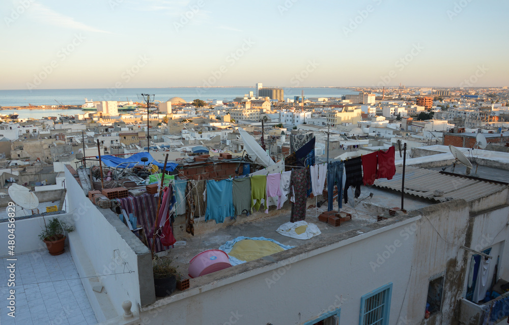 Obraz premium Drying laundry on the flat roof near medina in Sousse, Tunisia, Africa. Traditional Maghreb cityscape. Old town and sea line on the background
