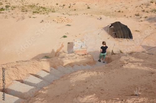 Fotografie Girl walking down the stairway from the roof of an Underground Troglodyte house in Tunisia, Africa