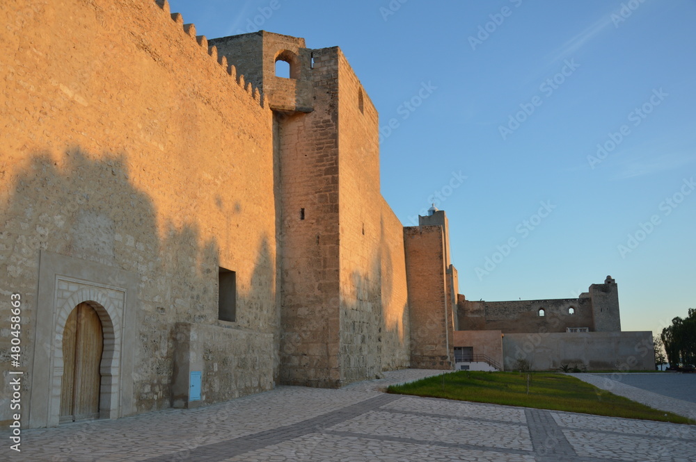 Ancient arabic fortress in Sousse, Tunisia, Africa. Warm sunset light, shadows on the walls and blue evening sky.
