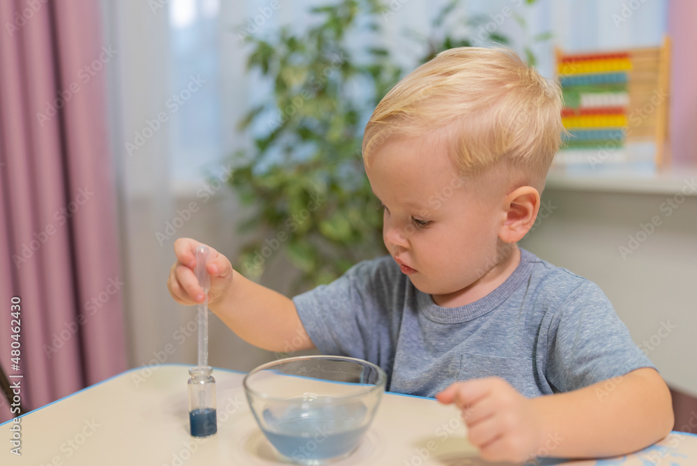 little boy child blonde play chemical experiments to sit at the table at home. little boy child blonde play chemical experiments to sit at the table at home.