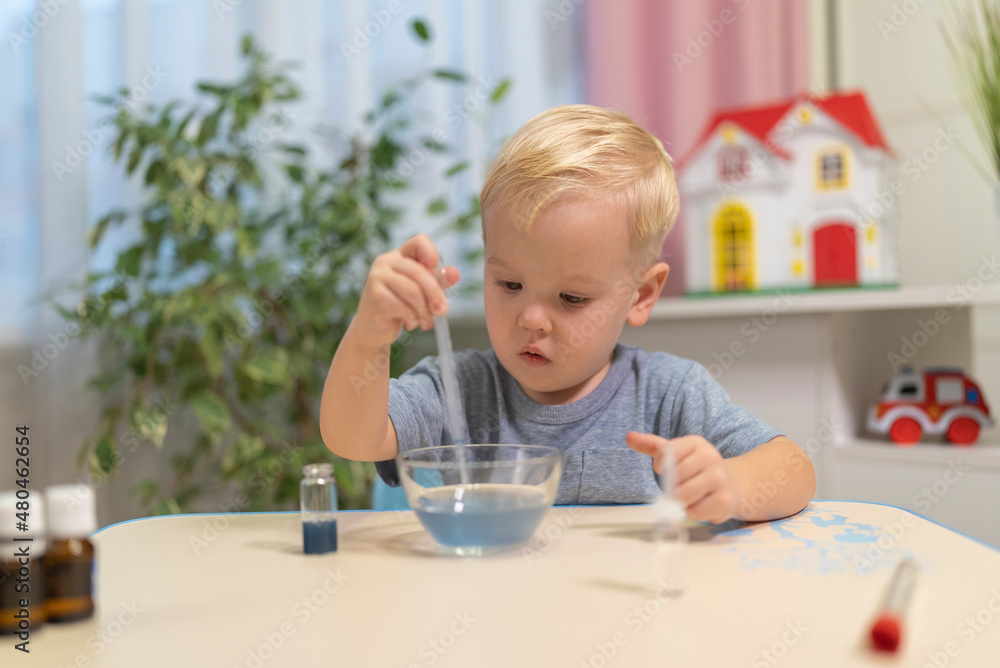 little boy child blonde play chemical experiments to sit at the table at home. little boy child blonde play chemical experiments to sit at the table at home.
