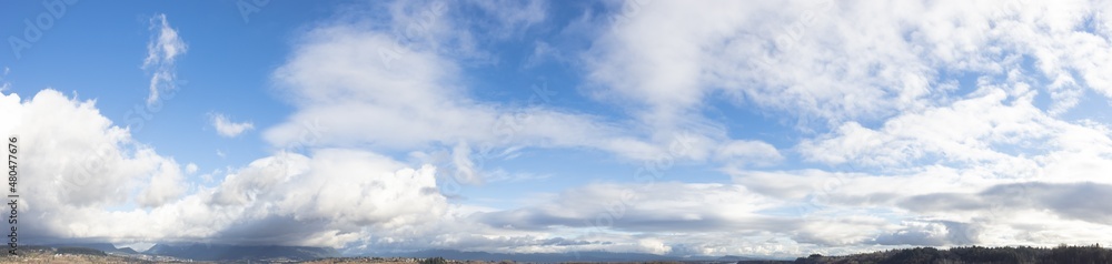 Panoramic View of Cloudscape during a cloudy blue sky sunny day. Taken over the Fraser River in Vancouver, British Columbia, Canada.