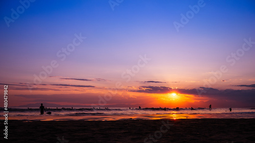 日本の綺麗な夕日と海岸の景色 サーフィンを楽しみむ人のシルエット