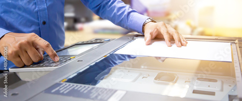 Copier printer, Close up hand office man press copy button on panel to using the copier or photocopier machine for scanning document printing a sheet paper and xerox photocopy. photo