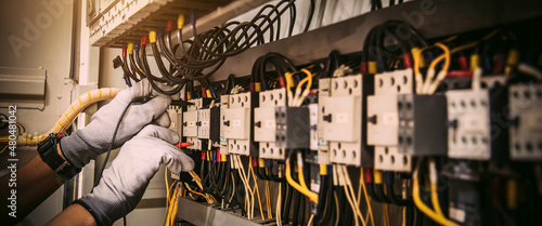 Tableau sur toile Electricity and electrical maintenance service, Engineer using measuring equipment tool checking electric current voltage at circuit breaker terminal and cable wiring main power distribution board