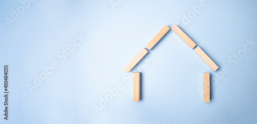 Wooden pegs in a shape of a house . Family insurance protection conceptual.