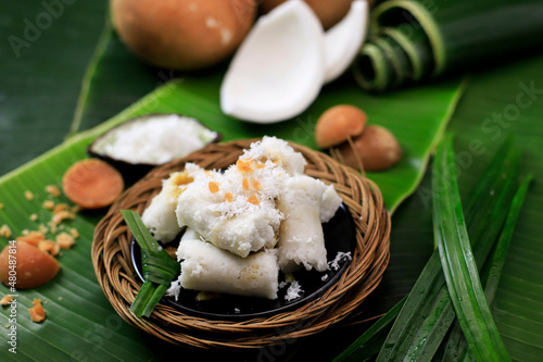 Kue Putu, Indonesian Traditional Cake Made from RIce Flour, Palm SUgar, Pandan Leaf, and Shredded Coconut. Come with Cylinder Shape with Bamboo Pipe photo